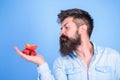 Man strict face with beard offers organic treats. I have treats for you. Man offers to try strawberries and apple fruit Royalty Free Stock Photo