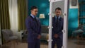 A man in a strict suit is standing in the living room in front of a mirror. Split personality. Royalty Free Stock Photo