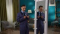 A man in a strict suit is standing in the living room in front of a mirror. Split personality. Royalty Free Stock Photo