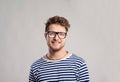 Man in striped t-shirt and eyeglasses against gray background. Royalty Free Stock Photo