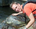 The man strokes an armor of a large turtle Royalty Free Stock Photo