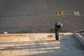 Man stroking cats at the entrance of the temple of Edfu. Egypt