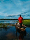 A photo of a man standing on a boat catching some fish for his family on a dam in sungai besar, Selangor, Malaysia.