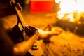 Man strumming an ukulele/guitar in the woods next to an open bonfire Royalty Free Stock Photo