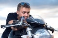 Man with a stubborn look leaned on the steering wheel of his bike Royalty Free Stock Photo