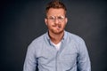 Man stuck with tough choice. Upset nervous and anxious handsome mature guy in glasses and denim shirt, biting lip and frowning