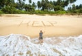 Man stuck on uninhabited island, inscription HELP on sand Royalty Free Stock Photo