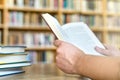 Man or student reading a book in public or school library.