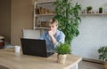 A man studies and takes notes with a laptop studying house plants, performs scientific work exploring botany