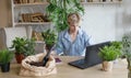 A man studies and takes notes with a laptop studying house plants, performs scientific work exploring botany