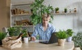A man studies and takes notes with a laptop studying house plants, performs scientific work exploring botany