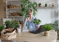 A man studies and takes notes with a laptop studying house plants, performs scientific work exploring botany