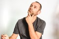 Man in studio, thoughtful hand resting on his chin, model expressions isolating white background