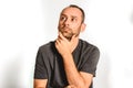 Man in studio, thoughtful hand resting on his chin, model expressions isolating white background