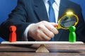 Man is studying a green opponent on scales. Study of conflicting parties. Search for compromise solutions. Confrontation Royalty Free Stock Photo