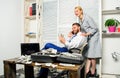 Man successful businessman phone conversation while assistant do shoulders massage. Office assistant gives massage boss Royalty Free Stock Photo