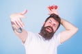 Man successful gardener king of strawberry blue background. Man bearded hipster holds hand with strawberries above head