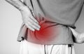 Man suffering from lower back pain. Backache with red spot closeup. Sedentary lifestyle, chronic health problems concept Royalty Free Stock Photo