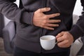 Cup Of Coffee In Front Of Man Having Stomach Pain