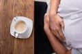 Cup Of Coffee In Front Of Man Having Stomach Pain