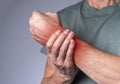 Man suffering from wrist pain and holding painful hand with red spot closeup. Hand injury. Health care, medicine concept