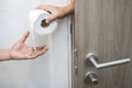 Man suffers from diarrhea hand hold tissue paper roll in front of toilet bowl. constipation in bathroom. Royalty Free Stock Photo