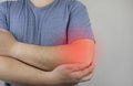 A man suffers from elbow pain. Damaged elbow joint, bone fracture, or sprain. Hand injury and flexion pain concept