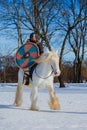 Man in suit of ancient warrior riding big white horse