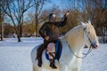 Man in suit of ancient warrior riding big white horse