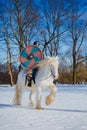 Man in suit of ancient warrior riding big white horse