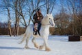 Man in suit of ancient warrior riding big white horse