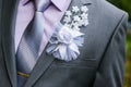 A man in a suit with a bow pinned to the chest wedding