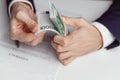 Man in suit counts wad of money before signing contract. Close up of hands with money Royalty Free Stock Photo