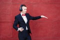 Man in a suit is dancing. Young guy is listening to music in big headphones through smartphone. Concept of good mood and Royalty Free Stock Photo