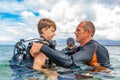 A man in a suit for diving prepares a boy to dive Royalty Free Stock Photo