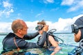 A man in a suit for diving prepares a boy to dive Royalty Free Stock Photo