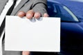 man in suit holding a blank signboard with a car in the background Royalty Free Stock Photo