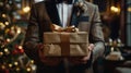 Man in Suit Holding Brown Gift Box