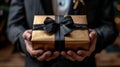 Man in Suit Holding Brown Gift Box
