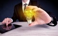 Man in suit holding a glowing yellow light bulb Royalty Free Stock Photo