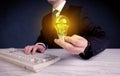 Man in suit holding a glowing yellow light bulb Royalty Free Stock Photo