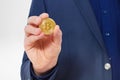 Stylish Man in suit holding gold bitcoin coin isolated on white background. Copy space and mock up. Selective focus and business Royalty Free Stock Photo