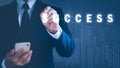 a man in a suit holding a mobile phone Left hand holding a pen pointing to the word success, background blur. The concept is Royalty Free Stock Photo