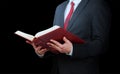 Man in suit holding opened book on a black background Royalty Free Stock Photo