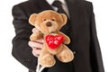 Man in suit holding teddy bear