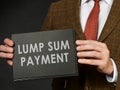 A man in a suit holds an inscription Lump sum payment.