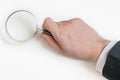 Man in suit holds magnifying glass. Isolated on white background