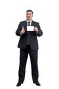 A man in a suit holds out a white card and shows a thumbs up Royalty Free Stock Photo