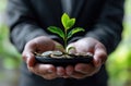 Man in suit holds tray of coins and small green plant, accountability concept