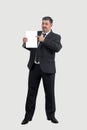 A man in a suit holds a white sheet of paper in his hands